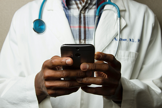 A doctor conducts telehealth via his smartphone.