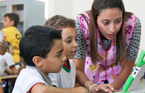 Students and teacher at computer in Colombia