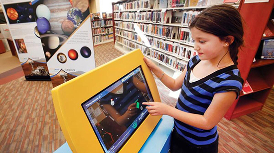 A girl uses a smart screen inside the Ignacio Public Library